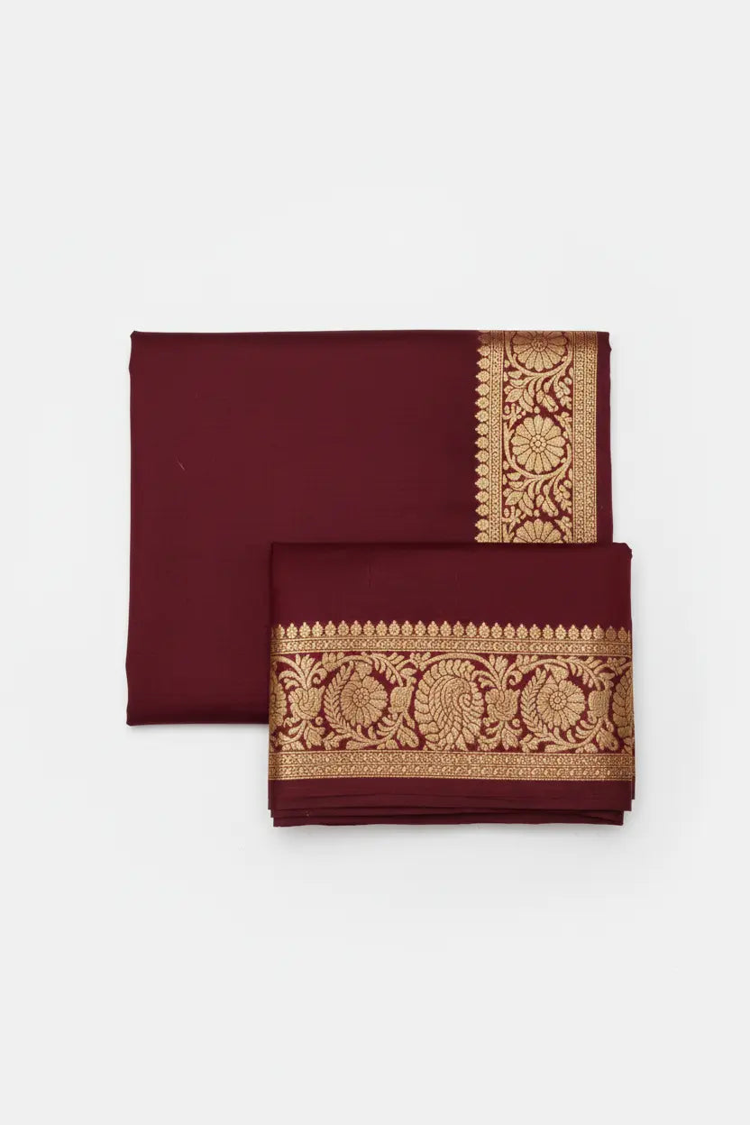 Maroon silk saree flat lay display with golden border and pallu