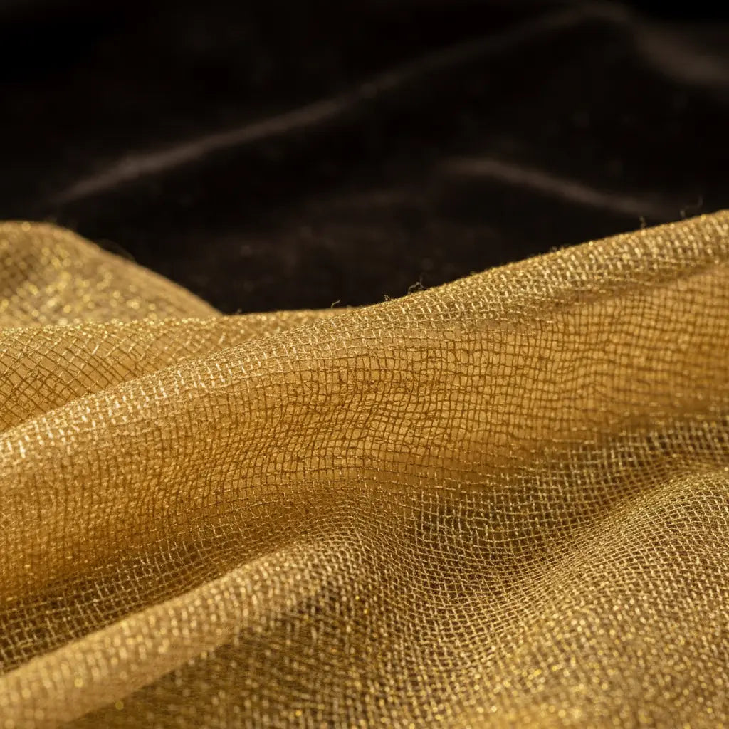 Close-up of golden silk tissue saree showing sheer translucent fabric with fine gold zari threads